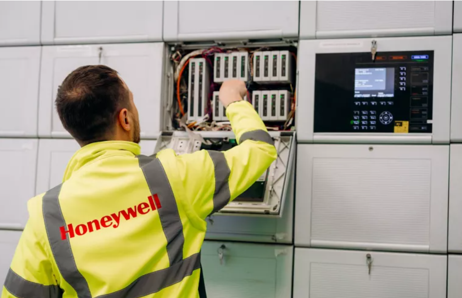 Technician in a Honeywell jacket adjusts industrial automation system