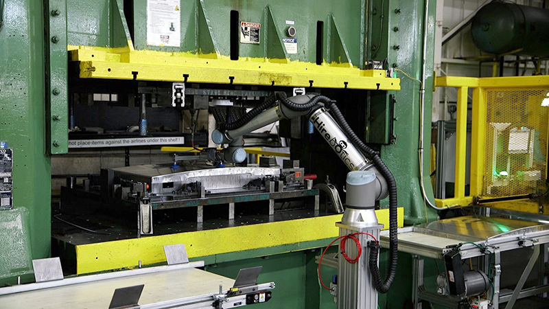 Having the UR10 cobots tend the mechanical presses demonstrates how the cobots work hand-in-hand with employees. The cobot picks and places the parts on the line in synchronicity with human colleagues who feed the raw stock and pick up the finished parts for further processing at each end of the line.